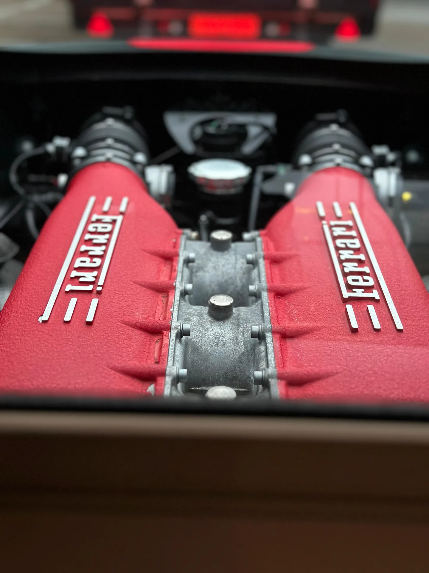 Close-up of a Ferrari V8 engine with red intake plenums
