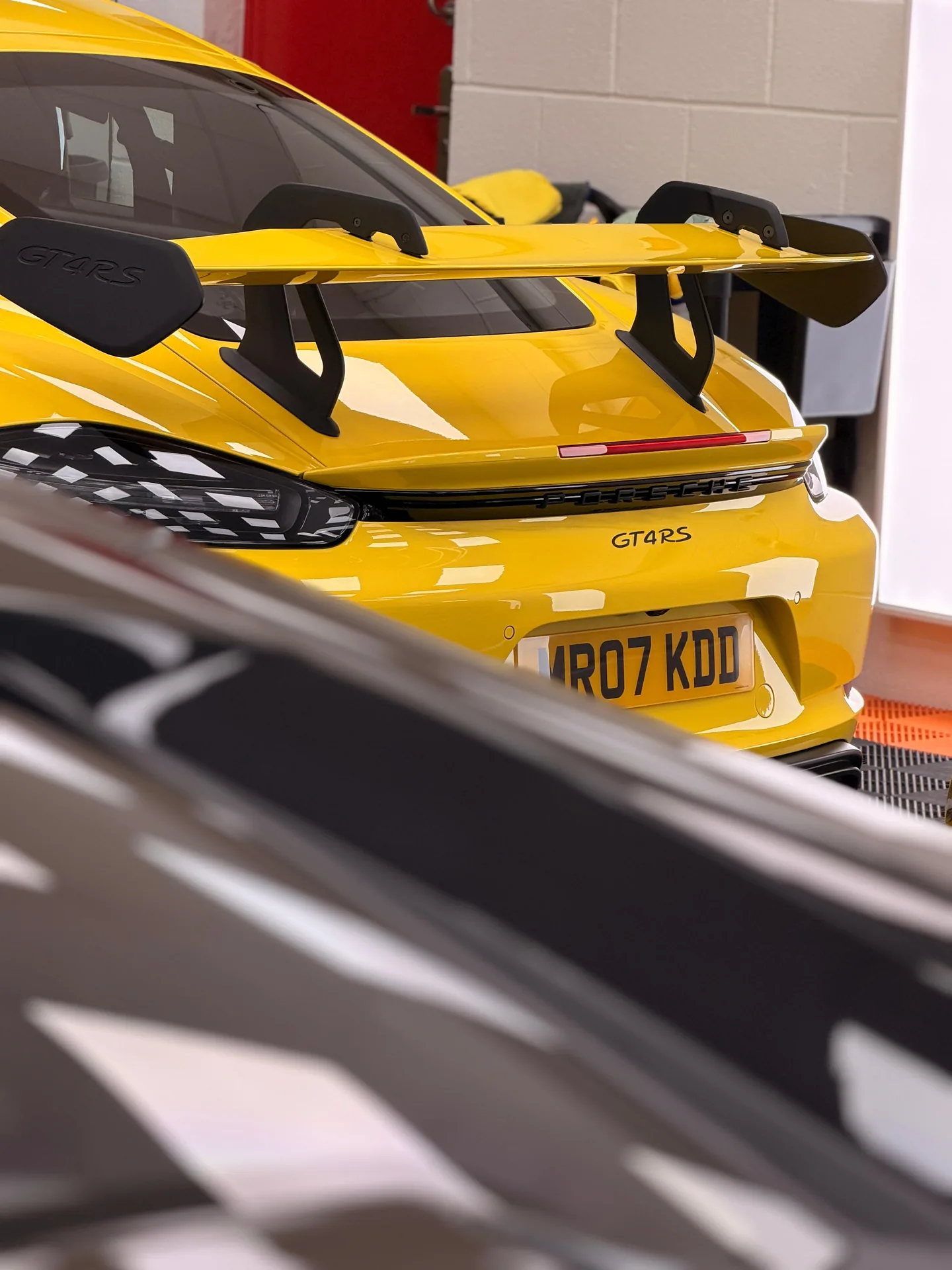 Yellow Porsche 718 Cayman GT4 RS rear wing in the Pure PPF studio