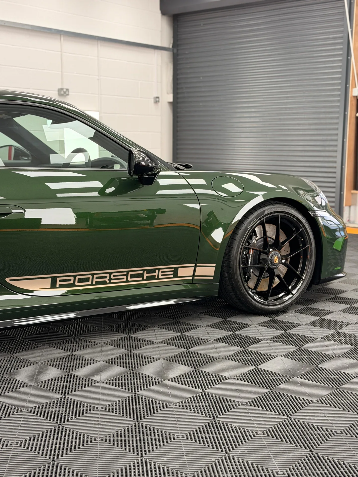 Green Porsche 911 side profile showing the front wing, door and sill