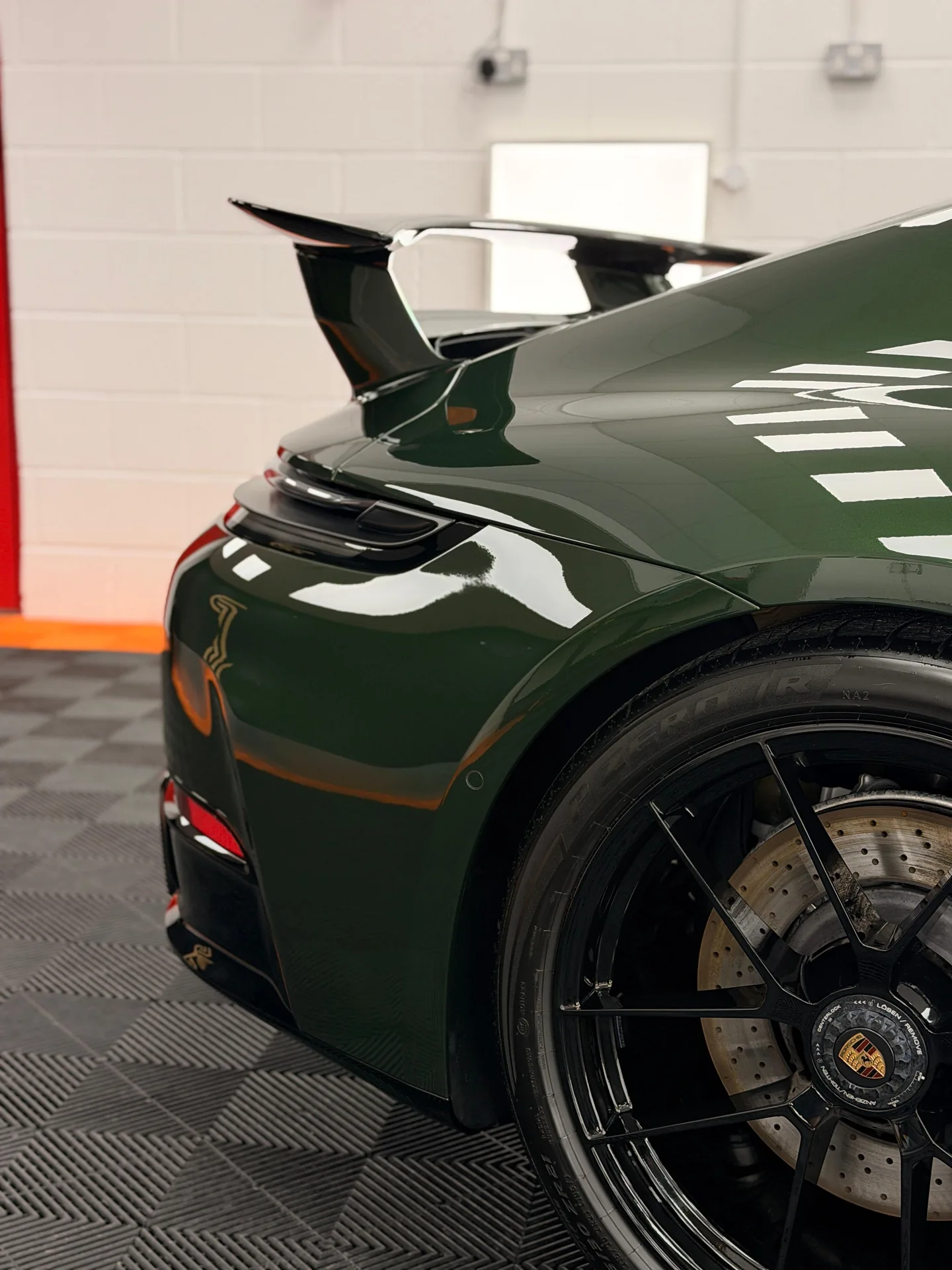 Green Porsche 911 rear wing, rear arch and centre-lock wheel