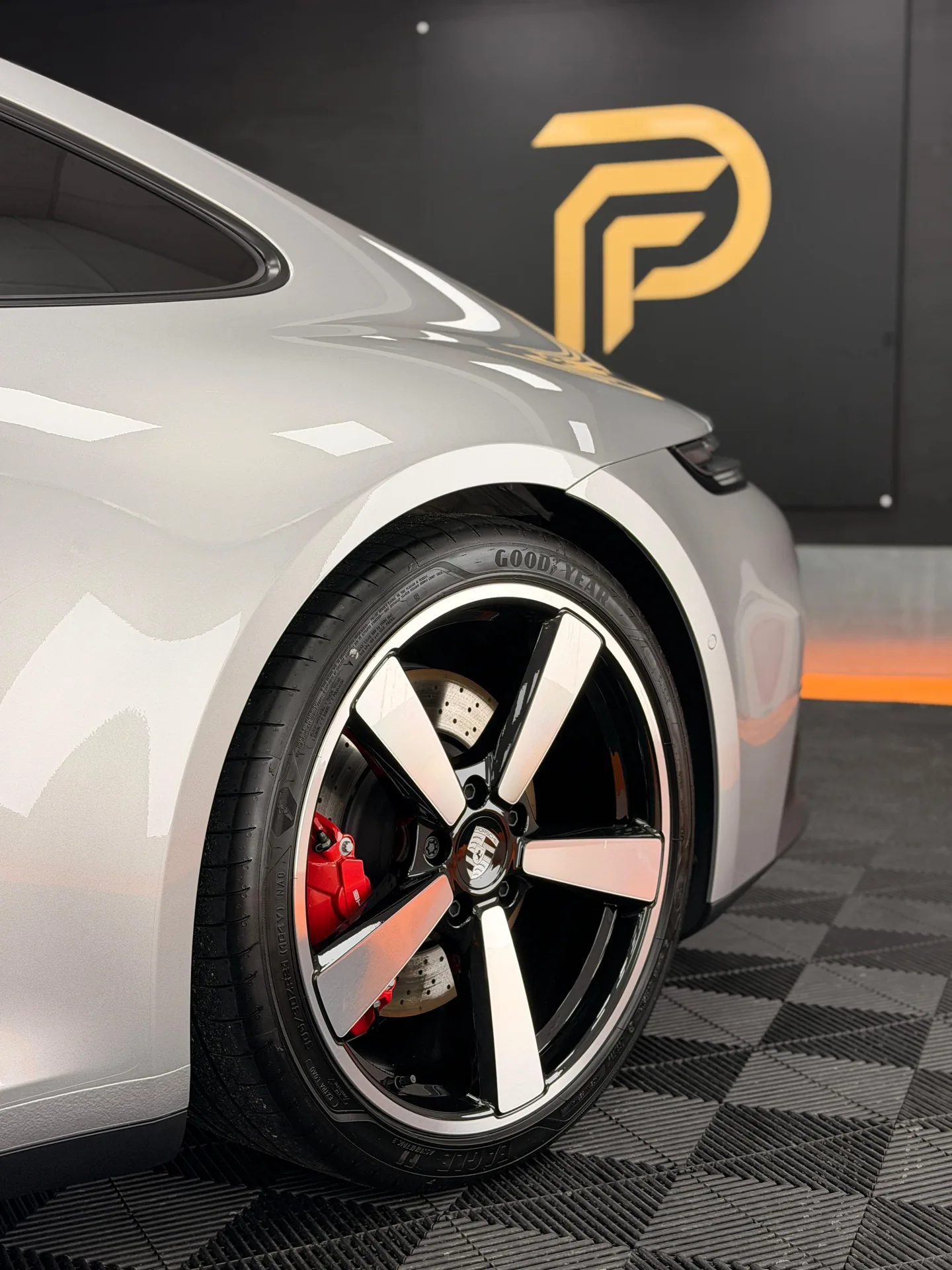 Silver Porsche 911 front wheel and wing in front of the Pure PPF logo